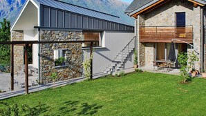 A modern house with a stone facade, a metal roof, and a view of mountains in the background. - Nice apartment in villa for 4 people with WIFI and terrace (Colico)