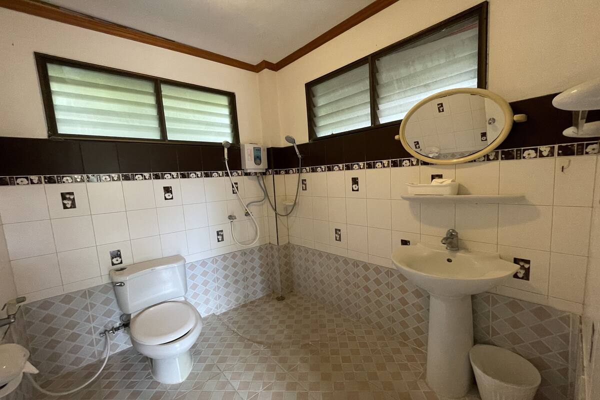 A bathroom with a toilet, sink, and shower.