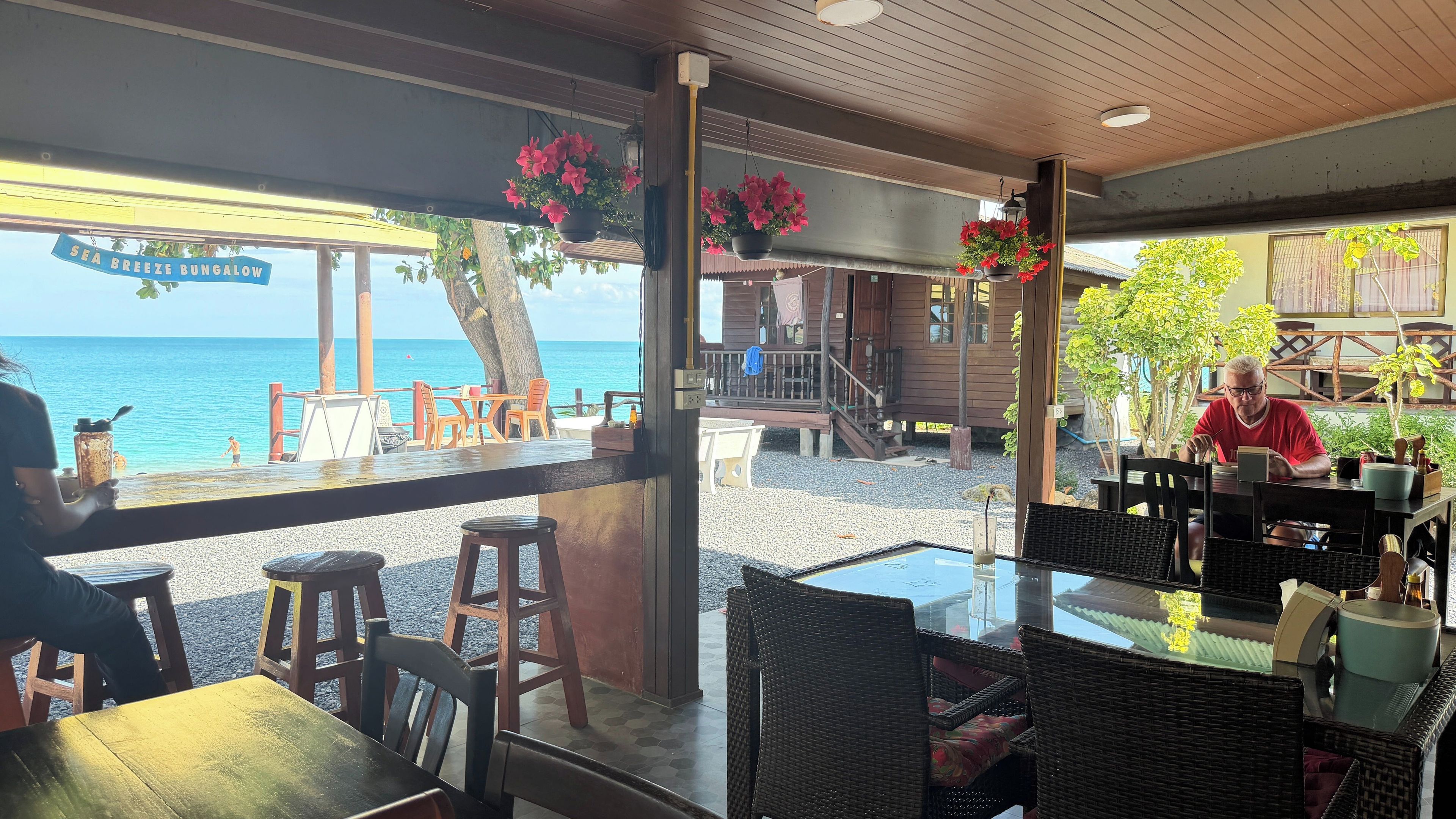 A seaside bungalow with outdoor seating and a view of the ocean.