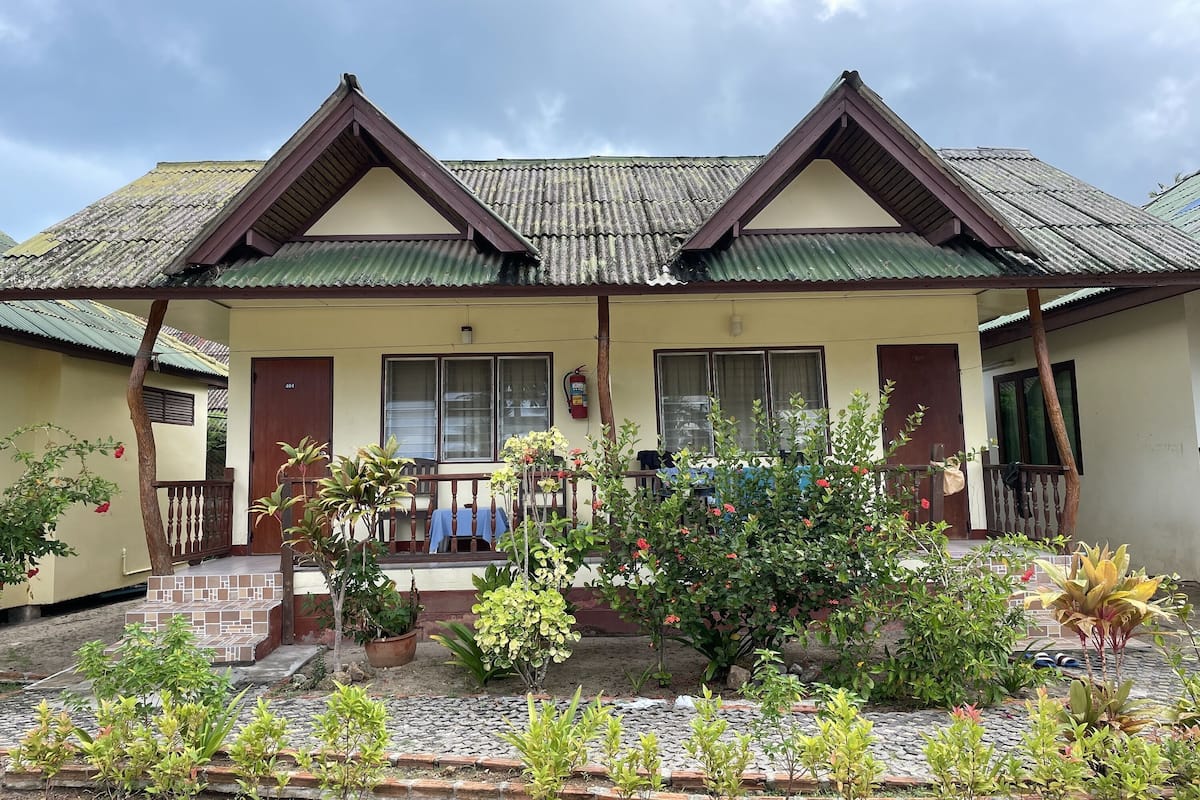 A two-story building with a tiled roof and a porch area.