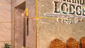 Un mur de marbre sur lequel est inscrit le texte « The Grand Lodge » et un panneau indiquant « Patty's Beds ».