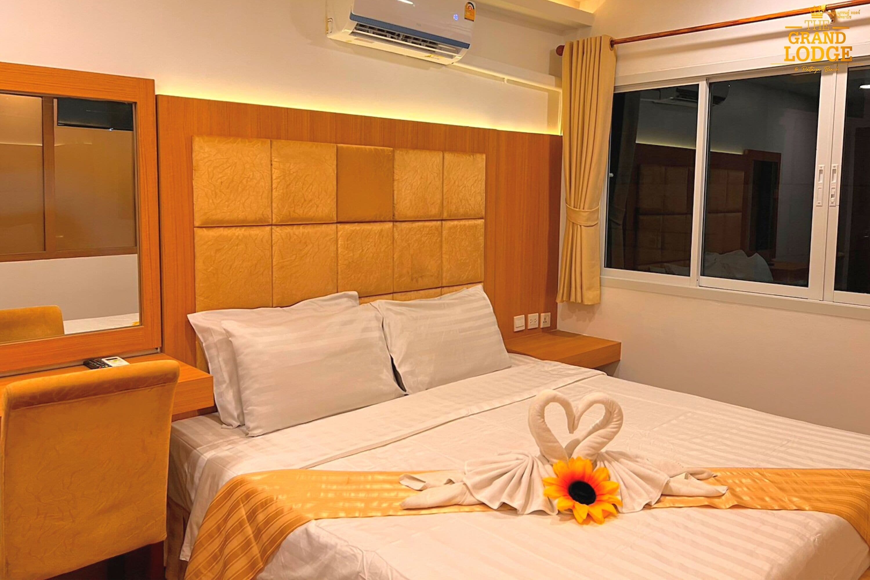 A hotel room with a bed, a nightstand, a chair, and a window with curtains.