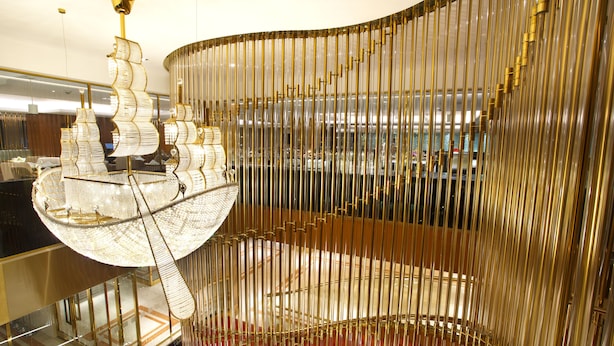 Un intérieur moderne, agrémenté d’un escalier en colimaçon doré remarquable et d’un grand lustre somptueux.