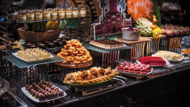 Un bufé con diversos postres y aperitivos.