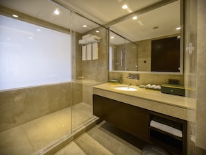 A modern bathroom with a glass-enclosed shower, a large mirror, and a vanity with a sink and towel rack. - Holiday Inn Dhaka City Centre by IHG (Dhaka)