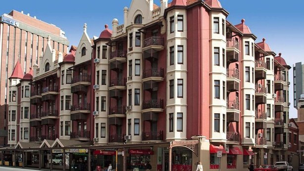 A multi-story hotel with balconies, a ground-level cafe, and a clear blue sky. - Boutique apartment in the heart of the Adelaide CBD (Adelaide)