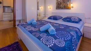 Une chambre à coucher comprenant un lit, deux tables de chevet, une commode, un miroir et un tableau accroché au mur.