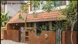 A house with a tiled roof, brick walls, and a gated entrance.