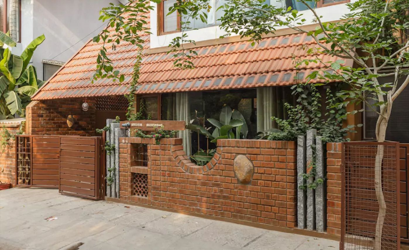 A house with a tiled roof, brick walls, and a gated entrance.