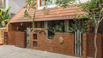A house with a tiled roof, brick walls, and a gated entrance.