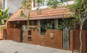 A house with a tiled roof, brick walls, and a gated entrance. - Relax in centrally located quiet terrace floor ensuite room in trendy eco-villa  (Bangalore)