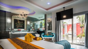 A modern hotel room with a large bed, a bathroom with a large mirror, and a view of the outside. - View Talay Villas Pattaya (Pattaya)