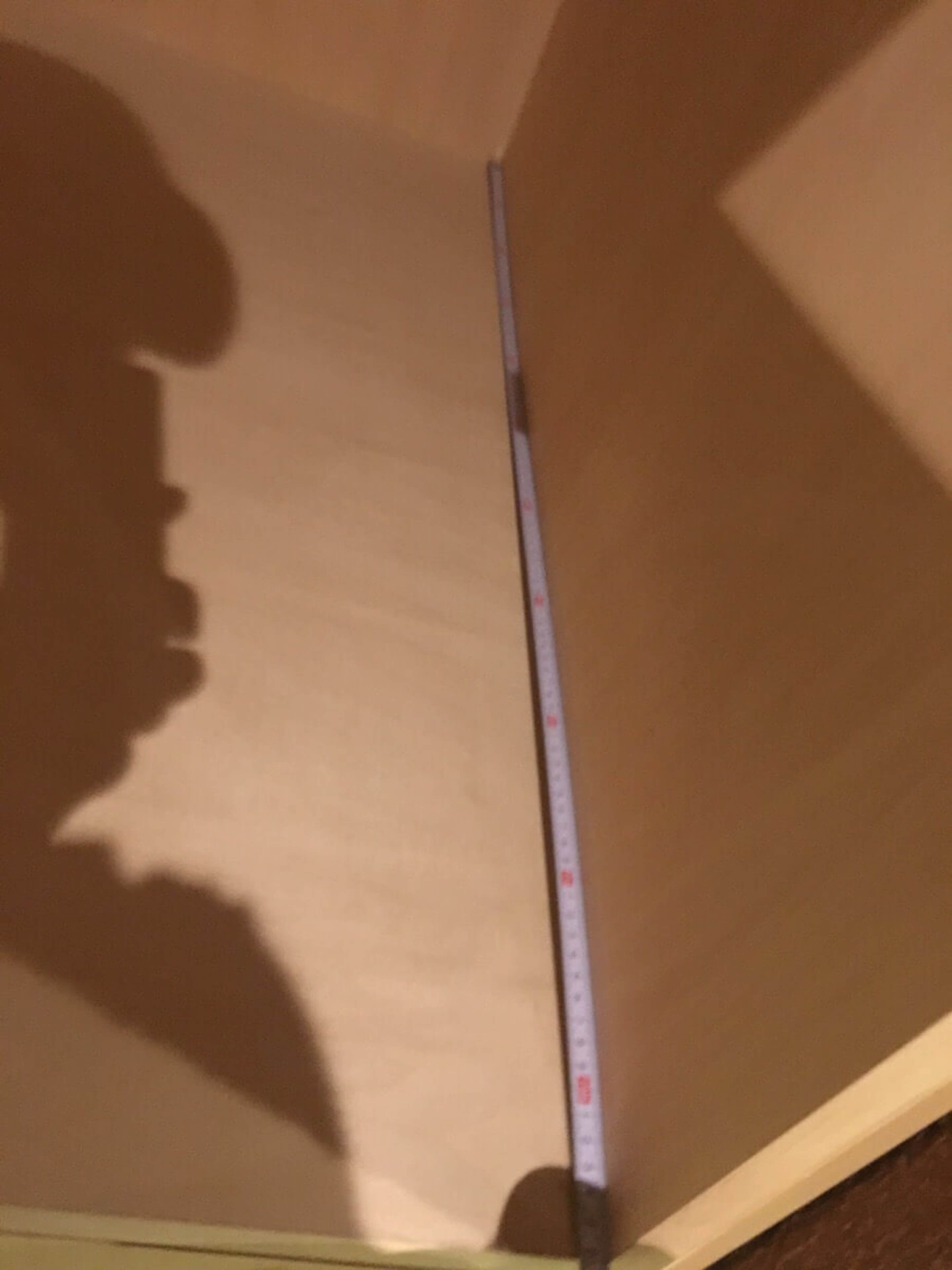 A room with a wooden ceiling and a measuring tape leaning against it.