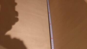 A room with a wooden ceiling and a measuring tape leaning against it.