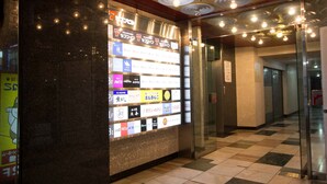 Un couloir d’hôtel avec un mur en verre présentant différents types de chambres et les équipements disponibles.