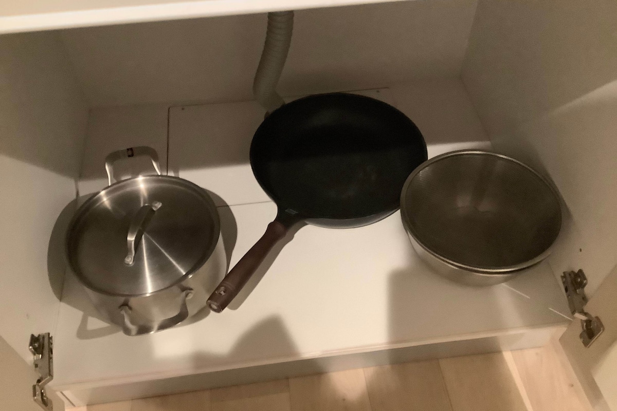 A kitchen with a stove, a frying pan, and a pot.