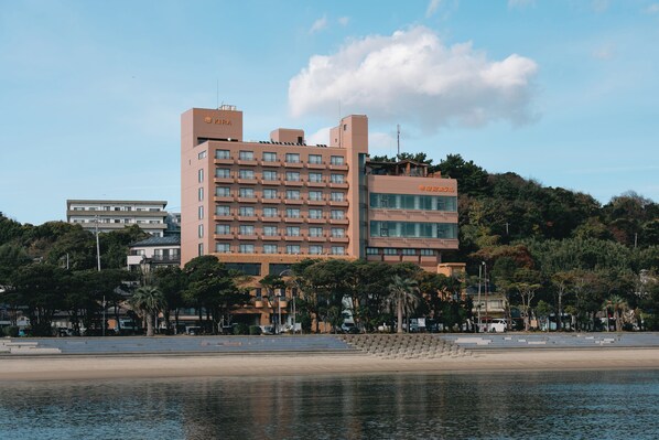A multi-story hotel with a modern design, located near a waterfront. - Ryuguhotel KIRA (Nishio)