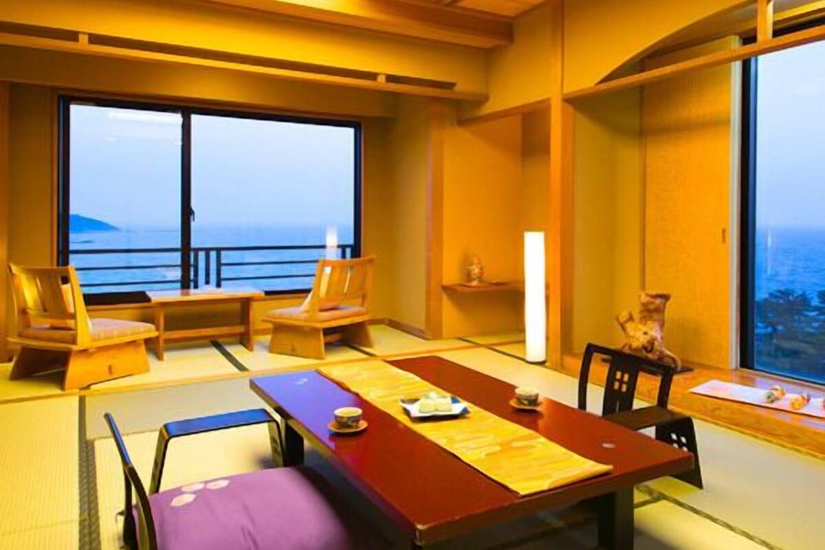 Une pièce de style japonais traditionnel, avec un sol recouvert de tatamis, une table basse et des chaises.