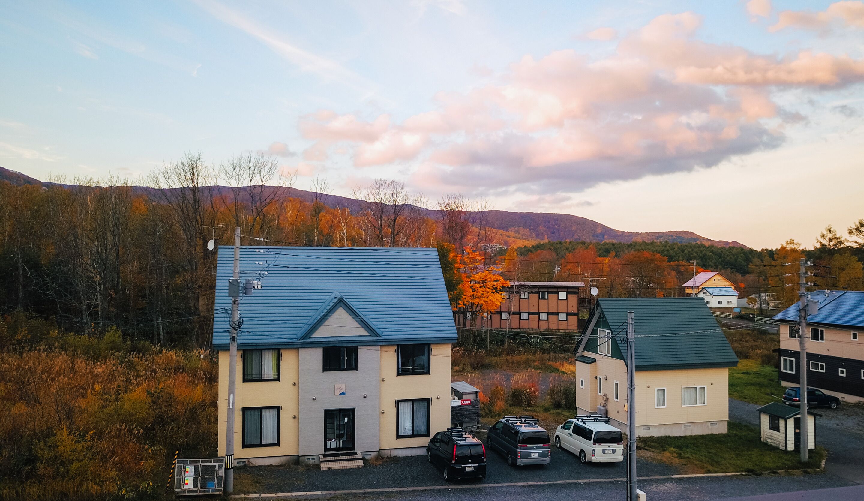 Un quartier résidentiel avec des maisons, un parking et un feuillage automnal.