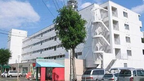 A multi-story building with a modern architectural design, featuring balconies and a central staircase.