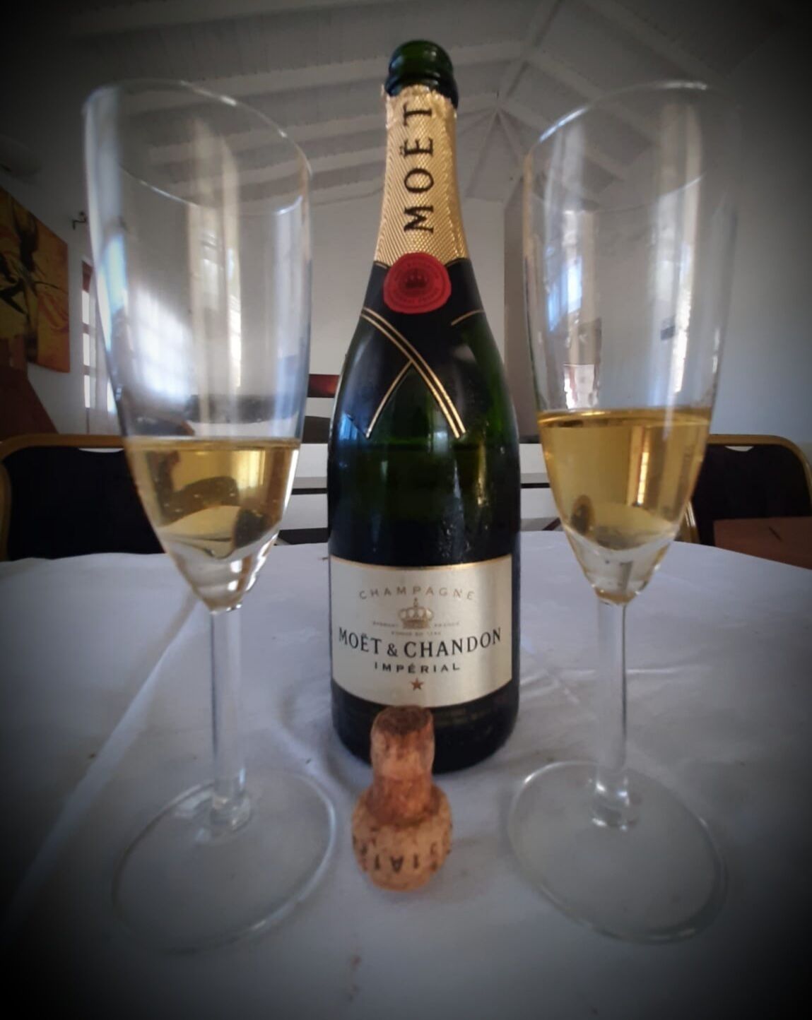 Una botella de Moët & Chandon Champagne Imperial sobre una mesa con dos copas de champán.