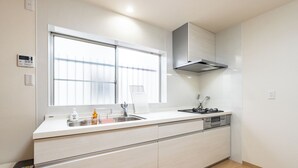 Eine moderne Küche mit großem Fenster, Edelstahlgeräten und einem eingebauten Backofen.