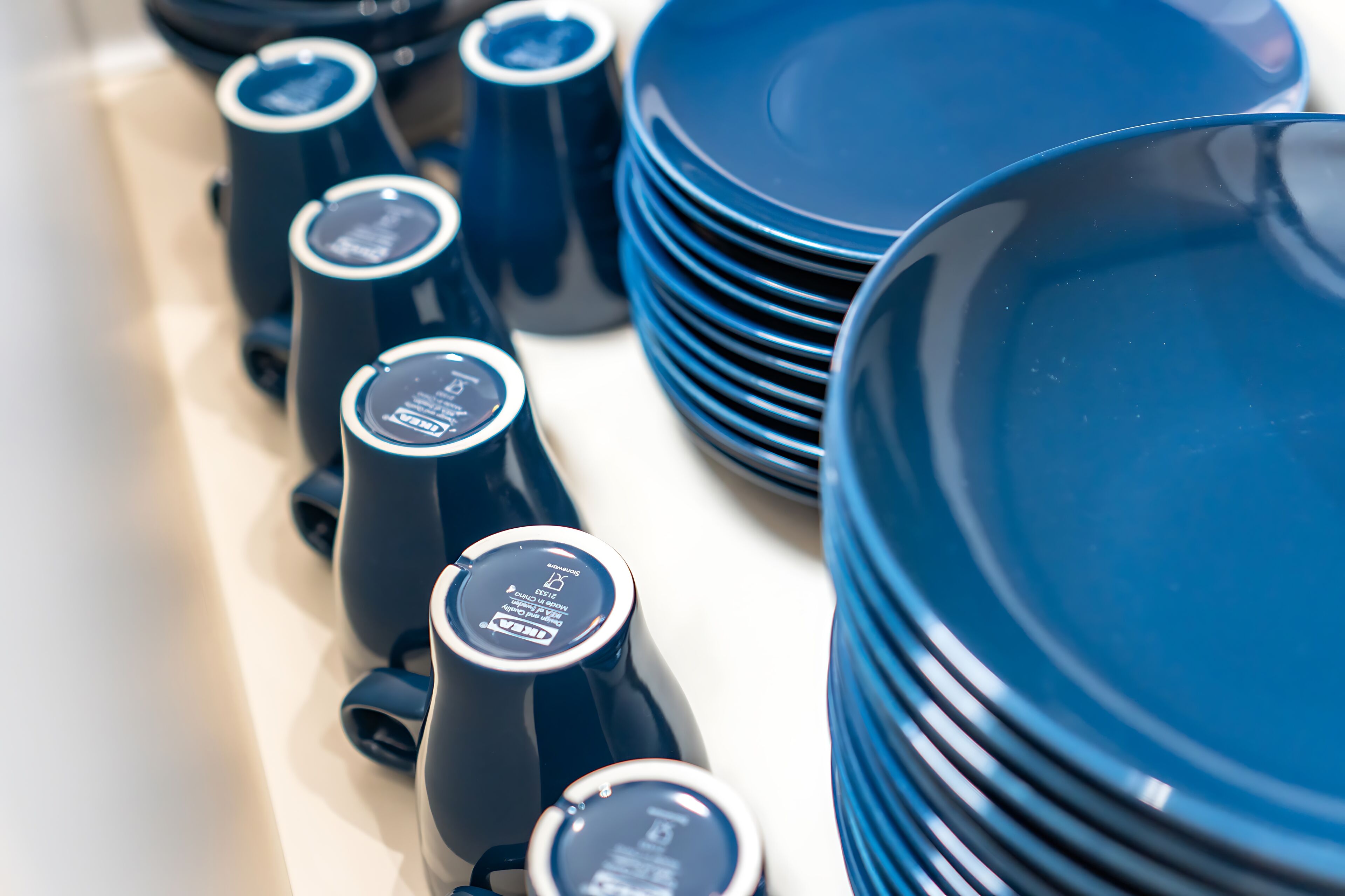 A collection of blue kitchenware, including plates and pitchers, arranged on a table.