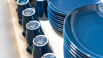 A collection of blue kitchenware, including plates and pitchers, arranged on a table.