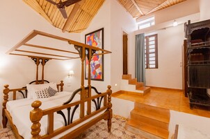 Quarto com cama de madeira com dossel, escada e lareira.
