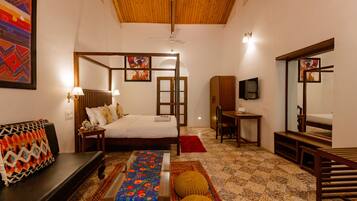 A bedroom with a bed, bedside table, lamp, and a wooden bench.
