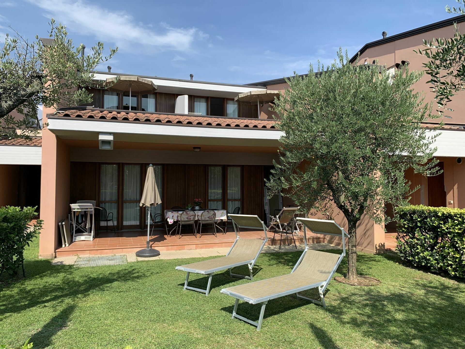 Un bâtiment moderne doté d’un patio couvert, d’un espace extérieur aménagé avec des sièges et de fauteuils de détente.