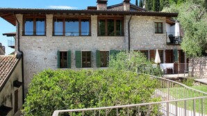 A stone building with multiple windows and a balcony.