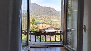 Una stanza con un balcone che si affaccia su un paesaggio montuoso.