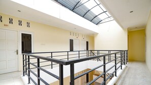 A hotel interior with a balcony, a staircase, and a reception area. - OYO 2856 Wisma Fortuna Syariah (Surakarta)