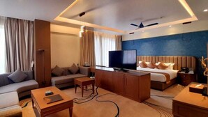 A modern hotel room with a sofa, a bed, a television, and a desk. - Wonder Country Club and Resort (Kharagpur)