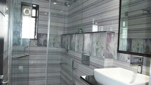 A modern bathroom with a glass shower enclosure, a white sink, and a large mirror. - Wonder Country Club and Resort (Kharagpur)