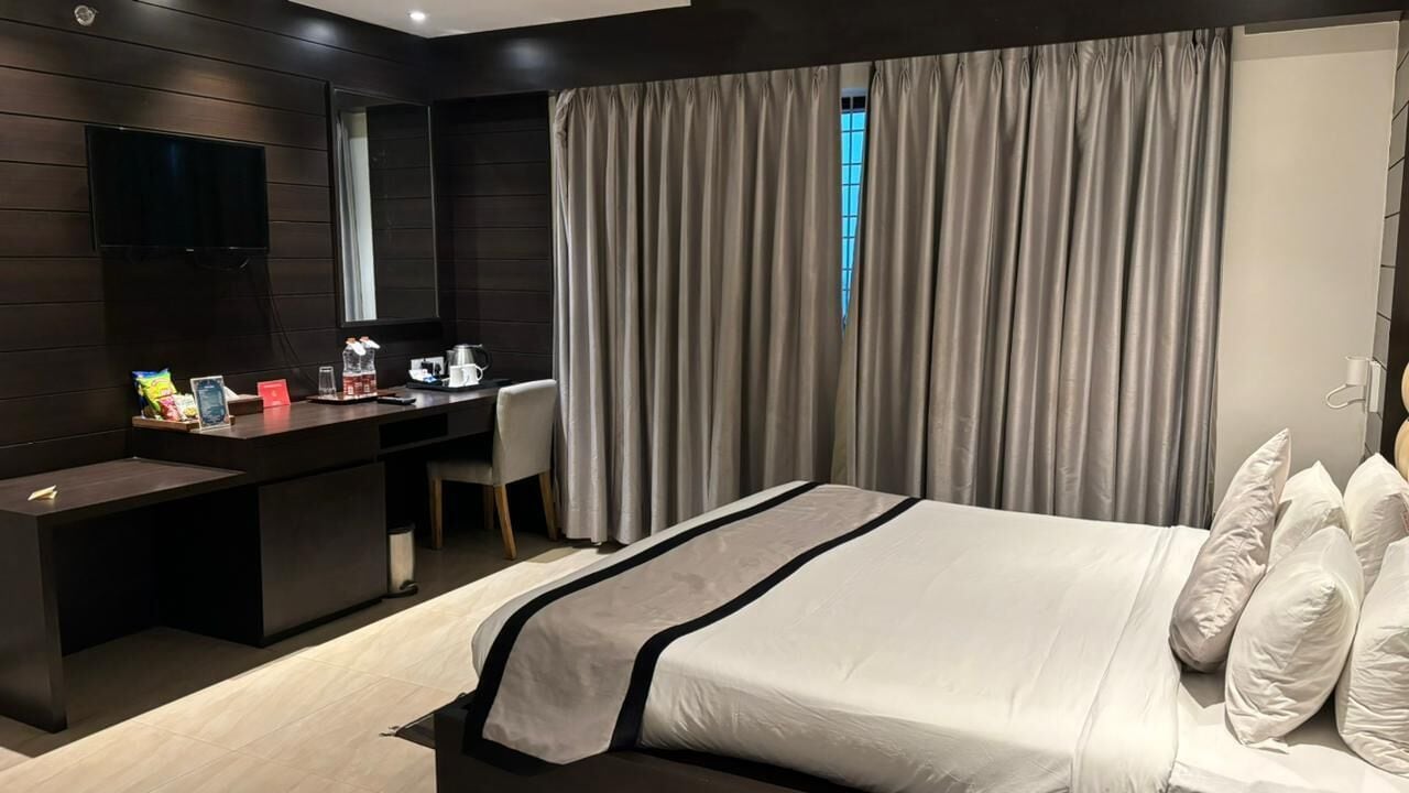 Una habitación de hotel moderna con una cama grande, un escritorio y una silla.