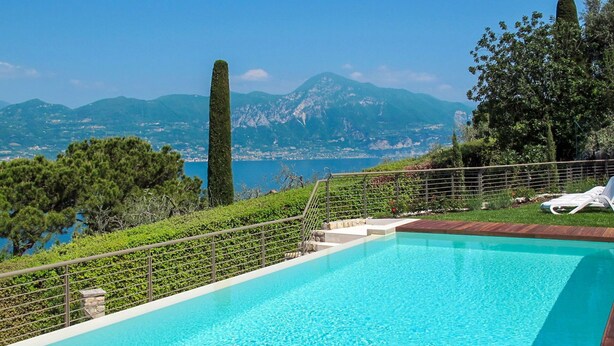 A swimming pool with a view of mountains and a body of water.