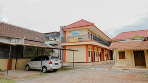 A two-story building with a red-tiled roof, a balcony on the upper floor, and a sign that reads "SPOT ON".