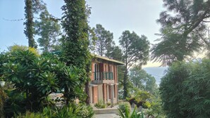 A two-story house with a balcony, surrounded by lush greenery and trees. - Azalea (Narendranagar)