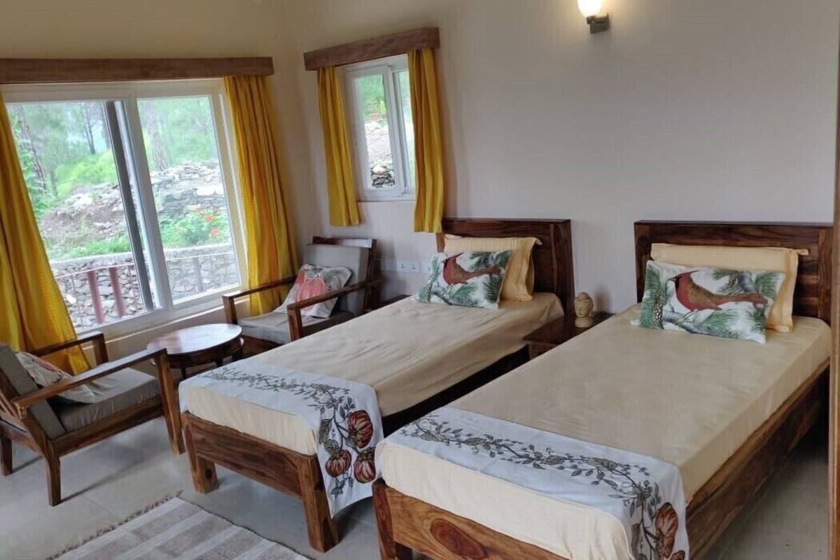 A room with two wooden beds, a small table, and a chair.