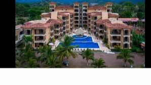 A multi-story hotel with a central courtyard and a swimming pool.