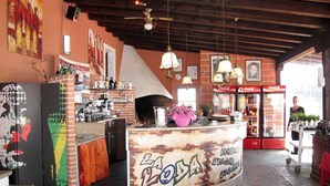 A bar area with a counter, shelves with bottles, a pizza oven, and a Coca-Cola fridge. - Lovely apartment for 7 people with pool, WIFI, TV and terrace (Corno)
