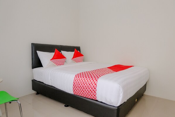 A bed with a black headboard, white bedding, and red accents. - Capital O 2798 Semeru Residence Syariah (Jember)