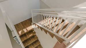 Una escalera con barandilla blanca y peldaños de madera.