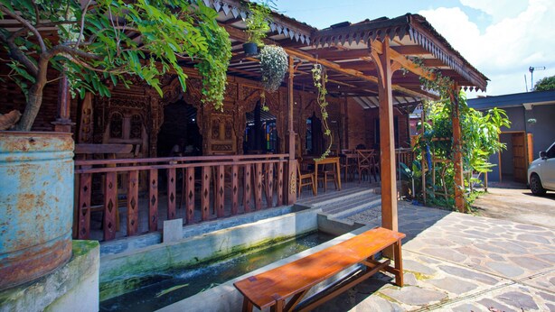 A traditional wooden structure with a covered patio, stone steps, and a small water feature. - Hotel O Pondok Kartini (Jepara)