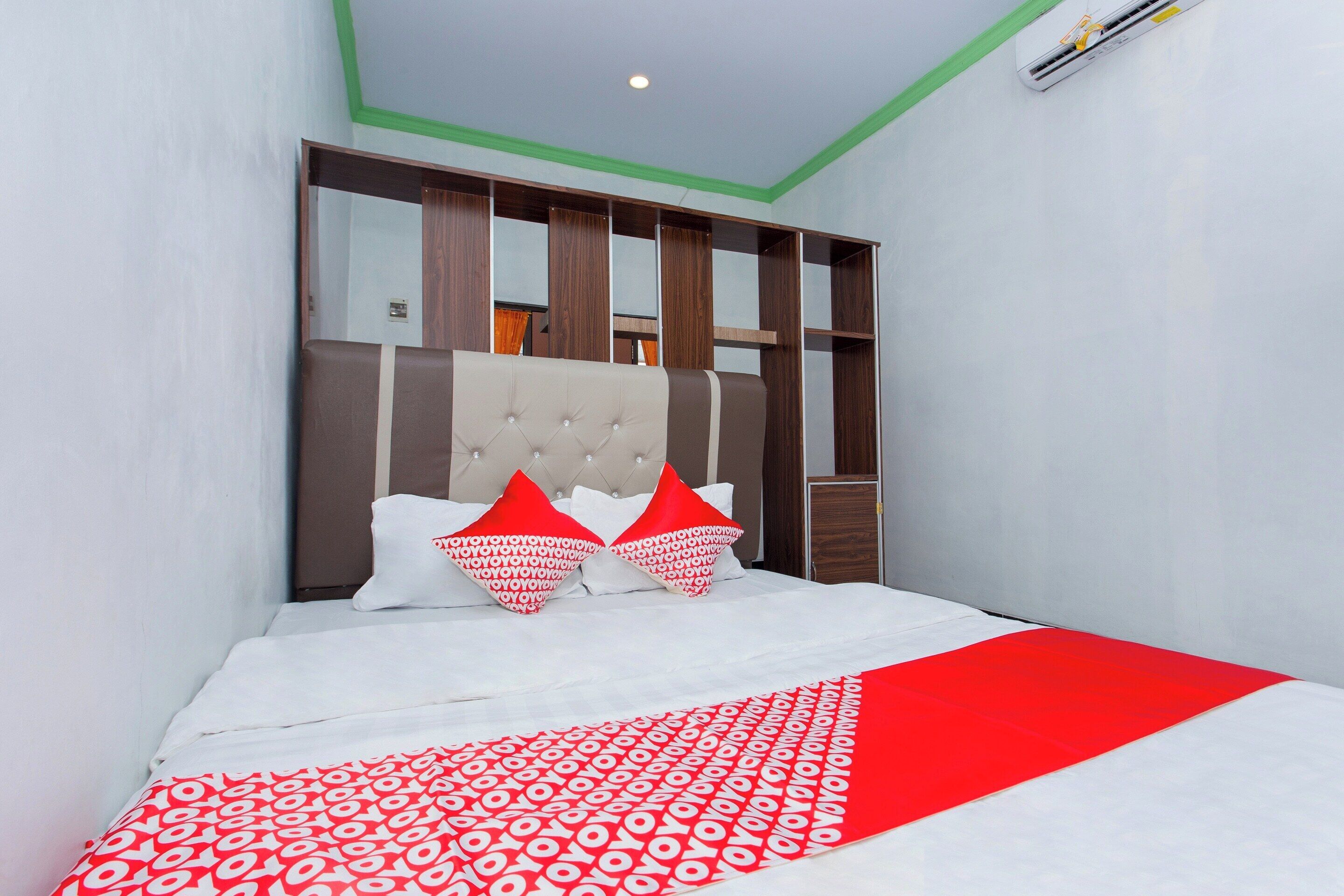 A bedroom with a bed, a headboard, and a wardrobe.