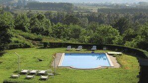 A swimming pool with lounge chairs and a view of a hilly landscape. - Nice apartment in villa for 6 people with pool, A/C, WIFI, terrace and pets allowed (Azzano D'asti)