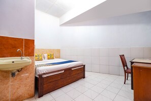 A bedroom with a bed, a wooden desk, and a sink. - Hotel O Sartika Inn Pati (Pati)