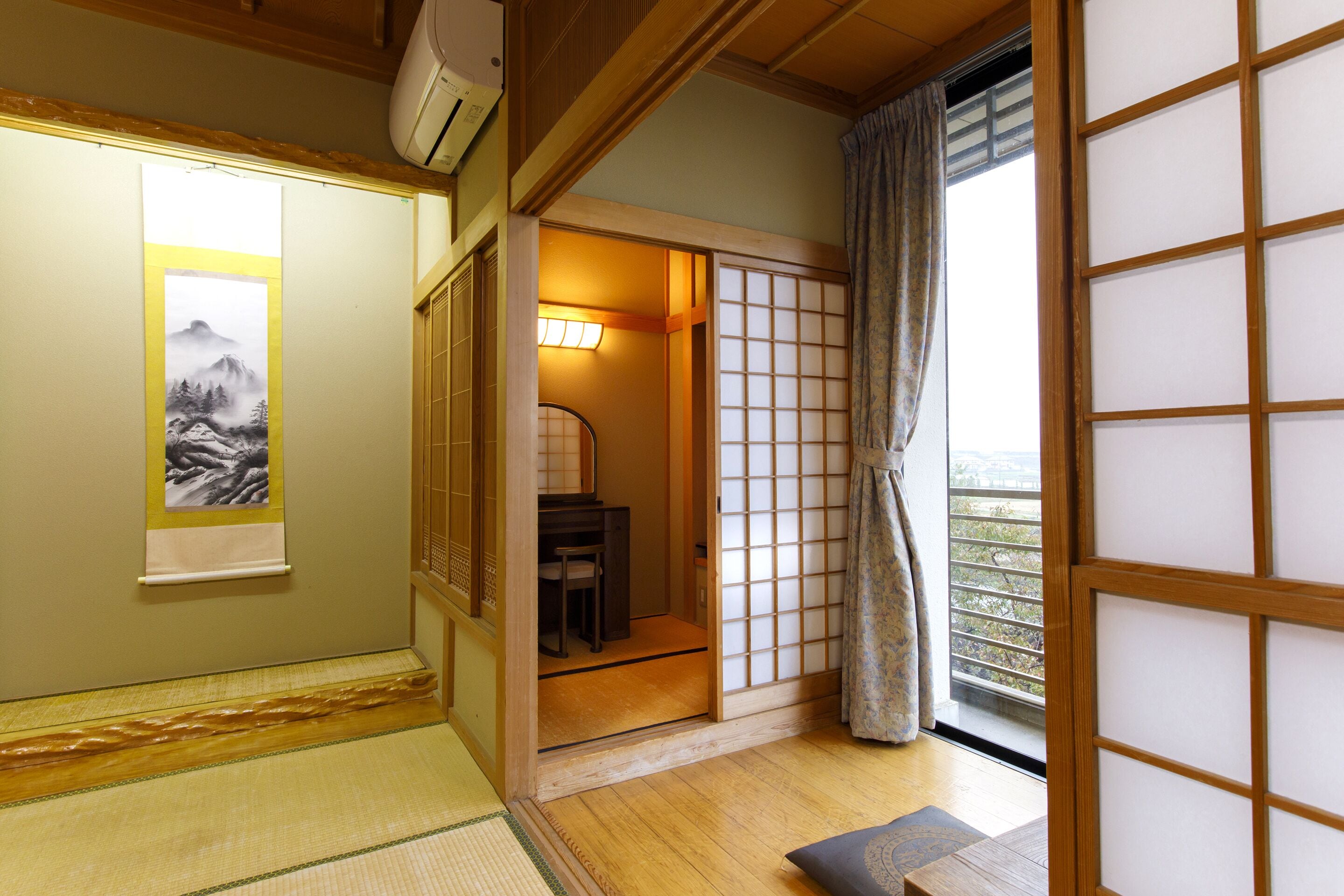 A traditional Japanese room with tatami flooring, a shoji screen, and a sliding door leading to a washbasin area.